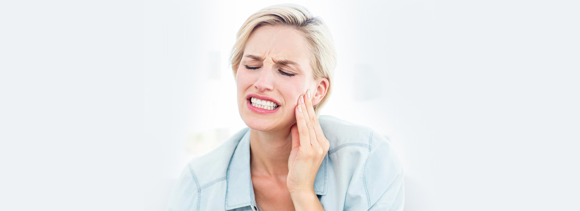 Woman with toothache needing emergency dental care in Cambridge