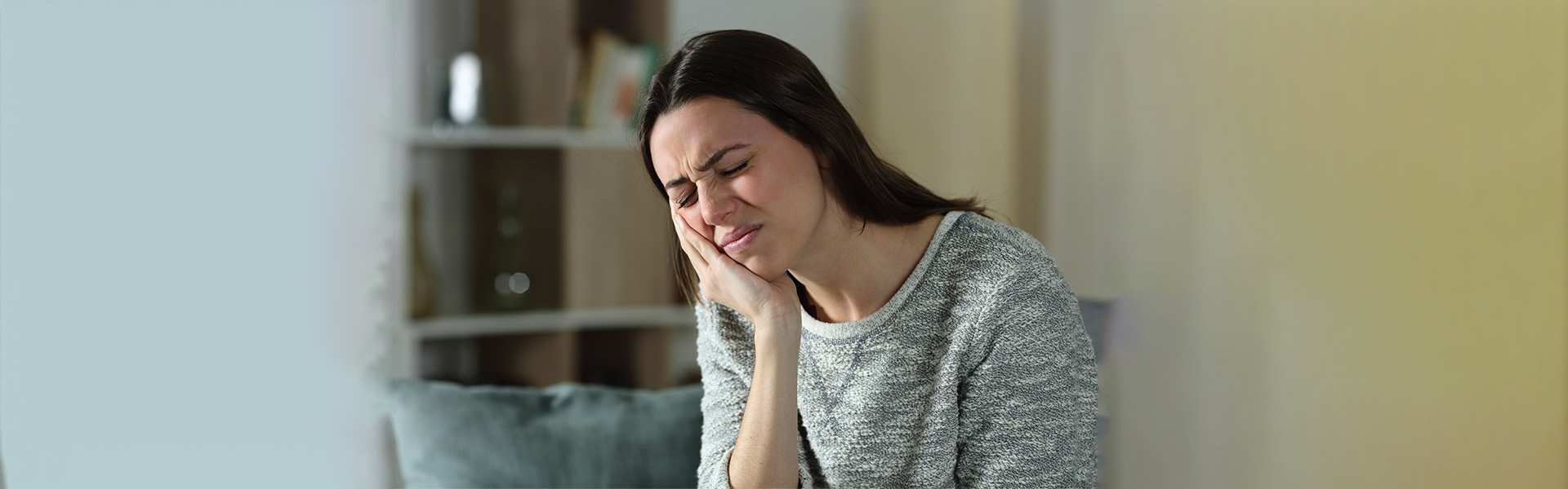 Woman with tooth pain needing root canal treatment in Cambridge
