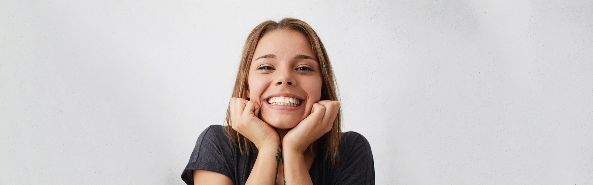 Smiling young woman showing teeth after dental bridge treatment in Cambridge