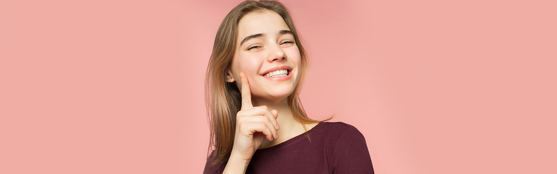 Smiling woman showing teeth after dental implant procedure in Cambridge