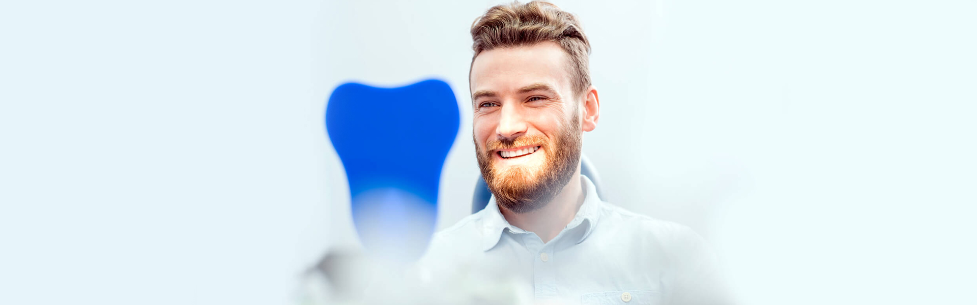 Man comparing smile shade during same-day dentures appointment in Cambridge