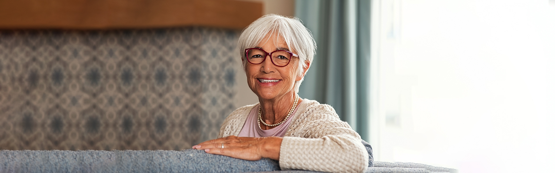 Senior woman smiling confidently with dental implants in Cambridge