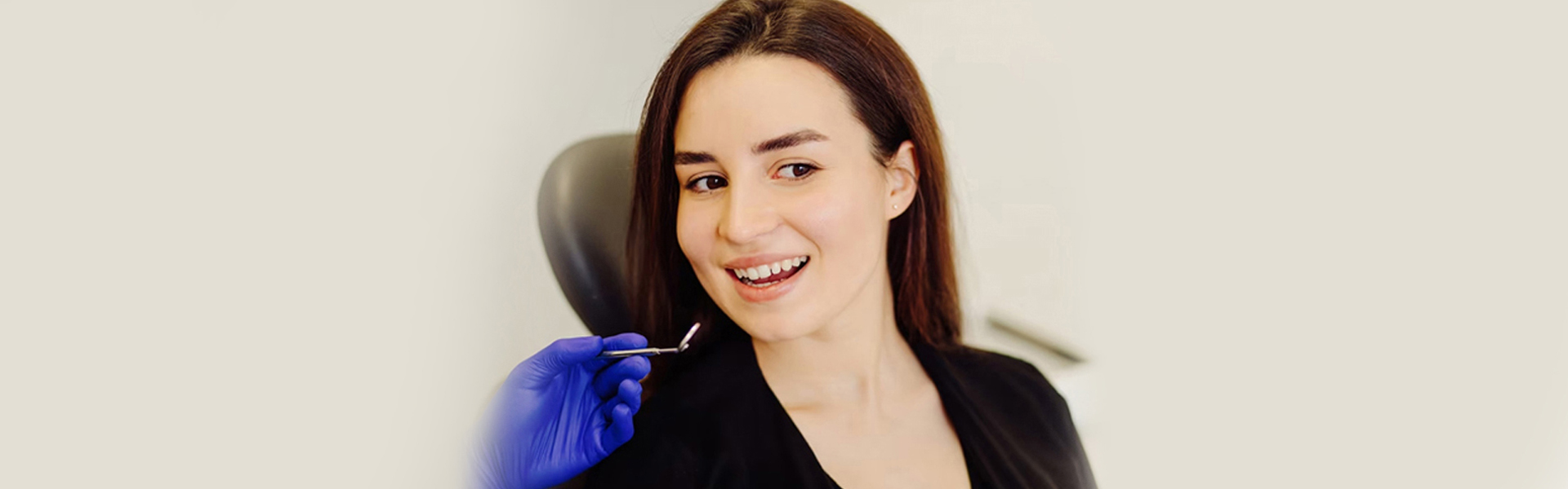 Smiling woman receiving care for dental bridge in Cambridge clinic