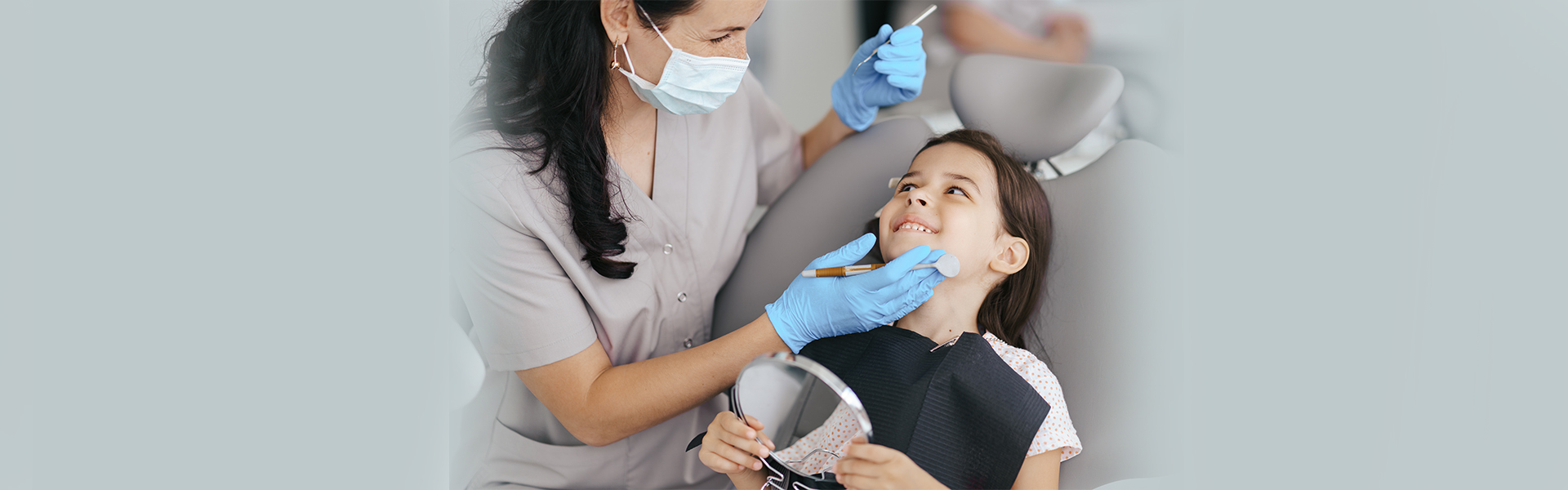 Dentist examining young child’s teeth during appointment in Cambridge