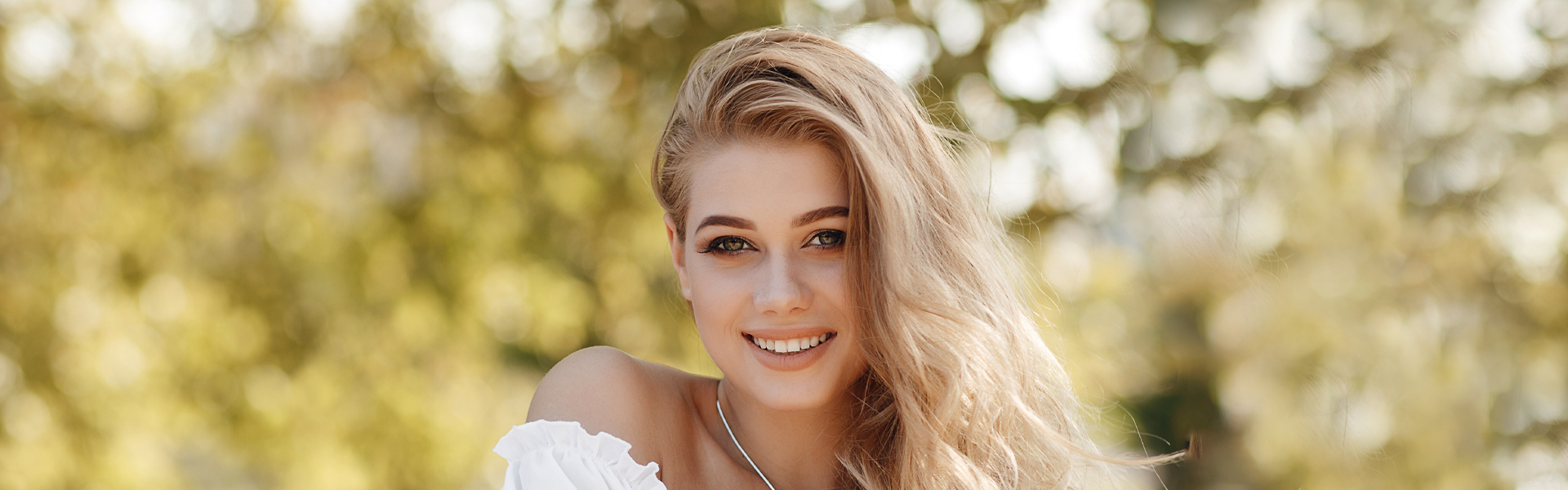 Smiling woman showing healthy teeth after dental crowns treatment.