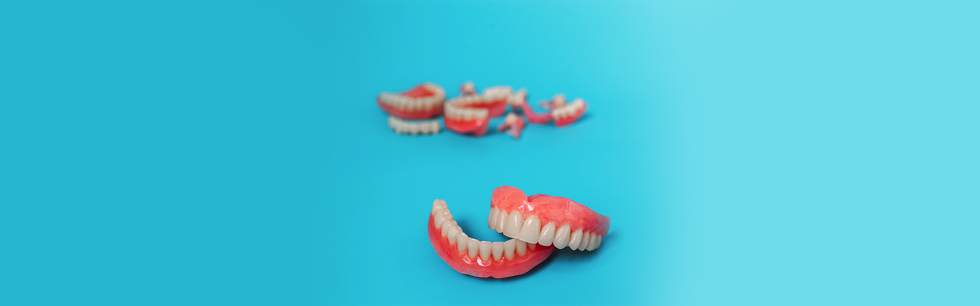 Set of immediate dentures placed on blue background.