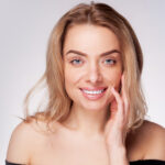 Woman smiling with bright white teeth after professional teeth whitening treatment.