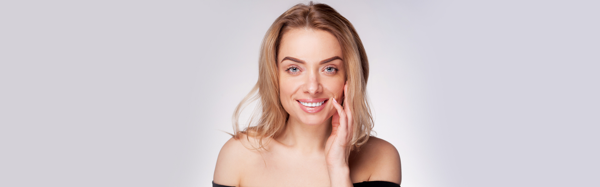 Woman smiling with bright white teeth after professional teeth whitening treatment.